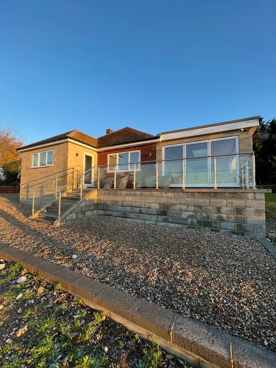 A glass and stainless steel rail around a raised deck