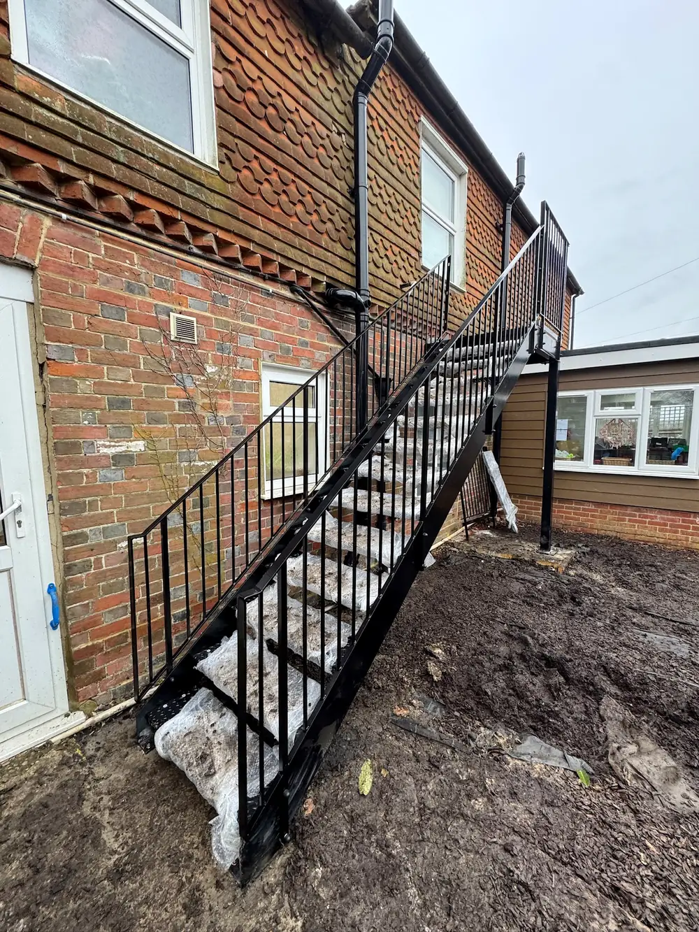 A black steel staircase on the outside of a brick building