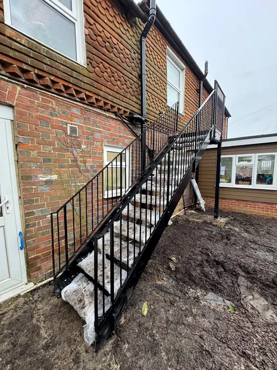 A black steel staircase on the outside of a brick building