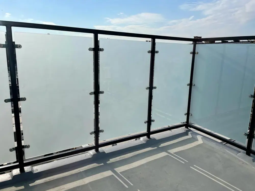 Glass panels between black posts around the edge of a flat roof