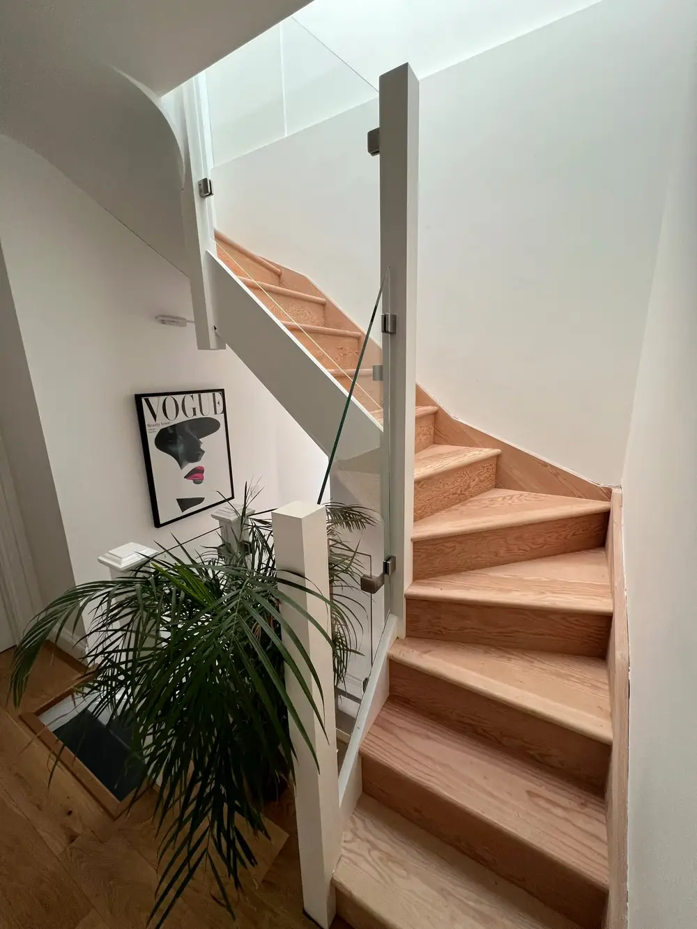 A frameless glass panel running up a timber staircase, so the timber is what you see