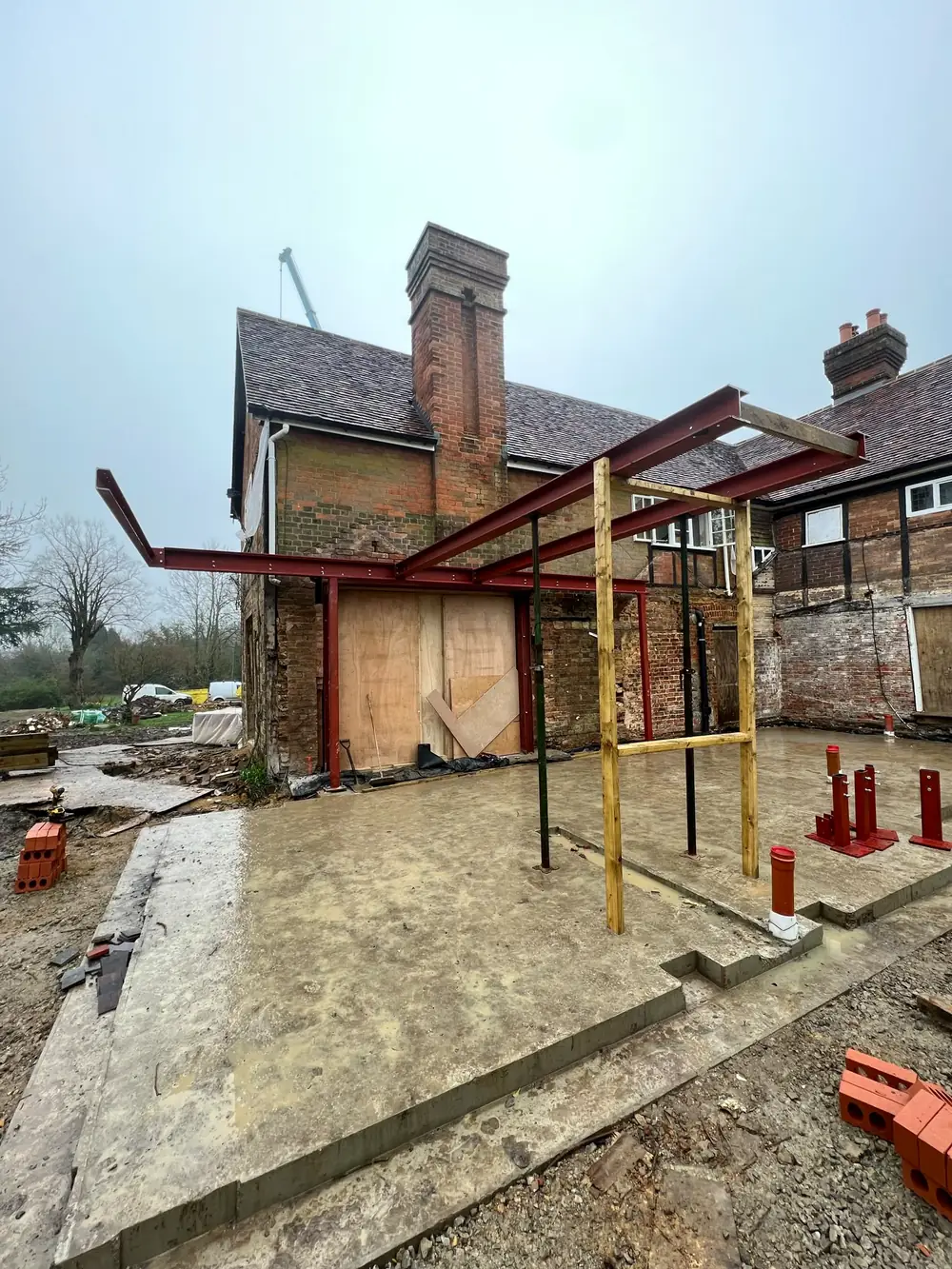 A red steel frame at the back of an old house