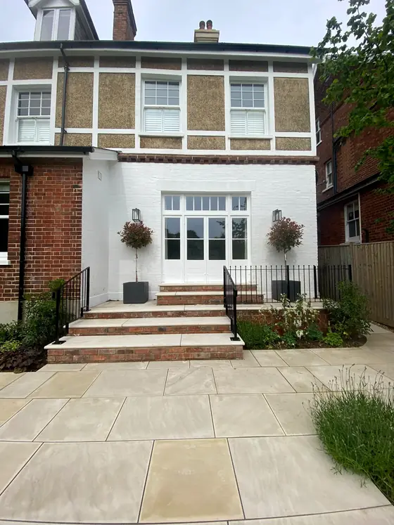 Black railings and steps at the front of an old white house