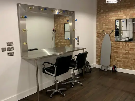 A stainless steel counter and mirror frame in a salon