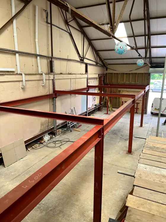 Red steel beams running across the inside of an industrial building