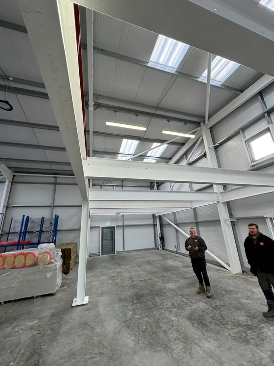 A white painted steel frame inside an industrial building